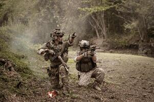 soldats dans camouflage uniformes visée avec leur fusilsprêt à Feu pendant militaire opération dans le forêt soldats formation dans une militaire opération photo