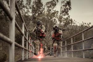 soldats dans camouflage uniformes visée avec leur fusilsprêt à Feu pendant militaire opération dans le forêt soldats formation dans une militaire opération photo