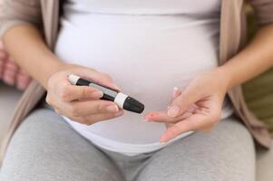 Enceinte femme vérification du sang sucre niveau par en utilisant numérique glucose mètre, santé se soucier, médecine, diabète, glycémie concept photo