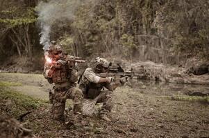 soldats dans camouflage uniformes visée avec leur fusilsprêt à Feu pendant militaire opération dans le forêt soldats formation dans une militaire opération photo