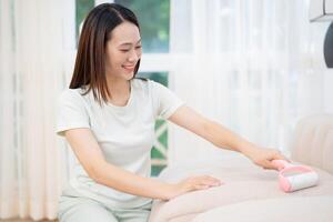Jeune asiatique femme nettoyage canapé photo