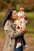 Jeune femme en portant mignonne bébé fille dans le l'automne parc photo