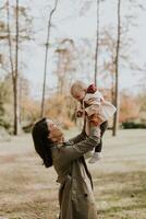 Jeune femme en portant mignonne bébé fille dans le l'automne parc photo