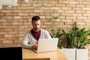 Jeune affaires homme travail sur portable dans le industriel style Bureau photo