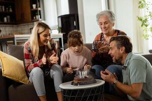 joyeux famille célébrer grands-mères anniversaire avec gâteau dans une confortable vivant pièce photo