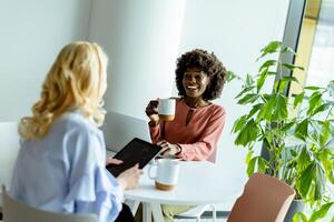 joyeux Bureau café Pause avec collègues partage une rire dans brillant espace de travail photo