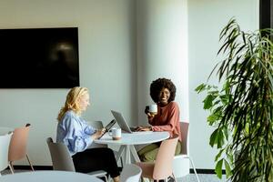 joyeux Bureau café Pause avec collègues partage une rire dans brillant espace de travail photo