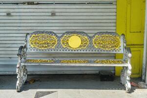 une parc chaise sur une piéton ou trottoir dans le ville de surabaya photo