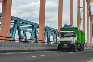 un isuzu giga déverser un camion passe plus de une béton cambre pont, Indonésie, 16 janvier 2024. photo