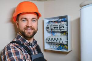 Beau Jeune homme électricien travail sur tableau électrique de maison bâtiment construction site photo