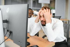 deux malheureux fatigué homme d'affaire, entreprise directeur, est assis à le lieu de travail, fatigué de en ligne travail, stressé, nerveux, massages le pont de le sien nez, fermé le sien yeux, expérience une mal de crâne photo