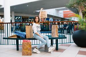 achats, bonheur et gens concept - souriant élégant adolescent fille avec achats Sacs. achats concept. photo