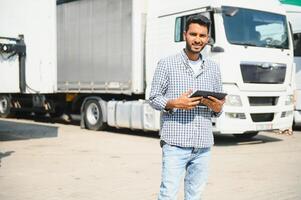 Jeune Indien homme permanent par le sien camion. le concept de cargaison transport. photo