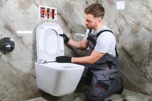 professionnel plombier travail avec toilette bol dans salle de bains photo