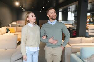 marié couple choisit le meilleur Nouveau canapé dans une meubles boutique photo