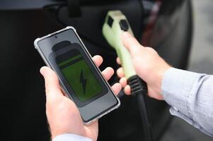 une homme des charges un électrique voiture photo