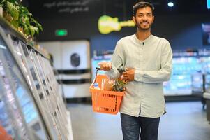 portrait de Indien Masculin dans épicerie avec positif attitude photo