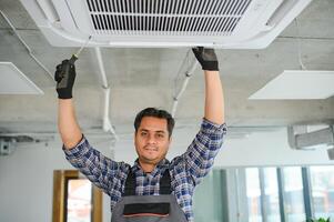 portrait de Jeune Masculin Indien technicien réparer air Conditionneur. air Conditionneur réparations. photo