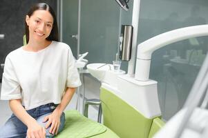 patient avec parfait blanc les dents et sourire satisfait après dentaire traitement dans une dentiste photo