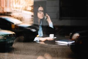 Jeune femme d'affaires parlant sur le téléphone dans café magasin photo