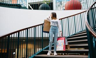 détail, geste et vente concept - souriant adolescent fille avec beaucoup achats Sacs à centre commercial. achats concept photo