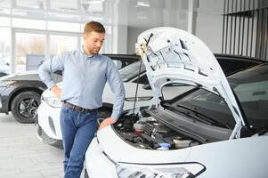 une content homme choisit une Nouveau électrique voiture à une voiture concession. le concept de achat un écologique voiture photo