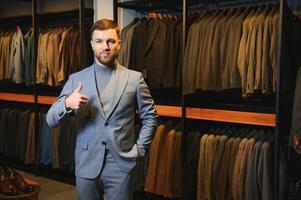 moderne Jeune Beau homme d'affaire, à la recherche et choisir classique costume dans le costume magasin photo