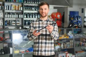 portrait de une Beau vendeur dans un auto les pièces magasin. le concept de voiture réparation photo