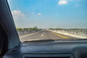 point de vue de à l'intérieur une voiture en voyageant à haute la vitesse sur une péage route photo