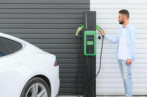 une homme des charges un électrique voiture photo