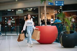 achats temps, adolescent fille avec achats Sacs à achats centre commercial. achats concept. photo