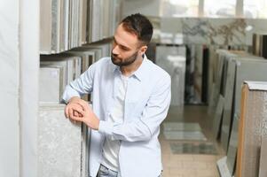 Jeune homme choisir carrelage à bâtiment marché photo