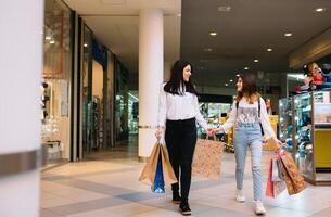 magnifique Jeune maman et adolescent fille sont en portant achats Sacs, achats dans centre commercial. famille achats photo