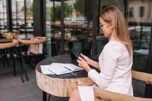 réussi affaires femme avec financier les documents permanent près une grand fenêtre dans une moderne Bureau photo