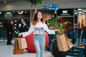 détail, geste et vente concept - souriant adolescent fille avec beaucoup achats Sacs à centre commercial. photo