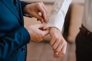 Masculin mains sur une Contexte de une blanc chemise, manche chemise avec boutons de manchette et montres, photographié fermer photo