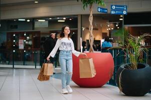 détail, geste et vente concept - souriant adolescent fille avec beaucoup achats Sacs à centre commercial. photo