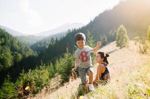 Jeune maman avec bébé garçon en voyageant. mère sur randonnée aventure avec enfant, famille voyage dans montagnes. nationale parc. une randonnée avec les enfants. actif été vacances. fisheye lentille. photo