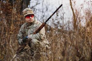 chasse permis. homme brutal garde forestier la nature Contexte. chasseur dépenser loisir chasse. chasseur tenir fusils. concentrer et concentration de expérimenté chasseur. chasse et piégeage saisons photo