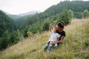 Jeune maman avec bébé garçon en voyageant. mère sur randonnée aventure avec enfant, famille voyage dans montagnes. nationale parc. une randonnée avec les enfants. actif été vacances. fisheye lentille photo