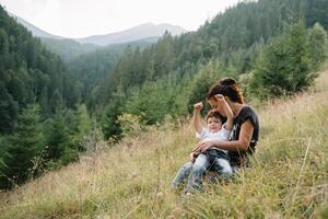 Jeune maman avec bébé garçon en voyageant. mère sur randonnée aventure avec enfant, famille voyage dans montagnes. nationale parc. une randonnée avec les enfants. actif été vacances. fisheye lentille. photo