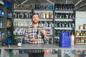 portrait de une Beau vendeur dans un auto les pièces magasin. le concept de voiture réparation photo