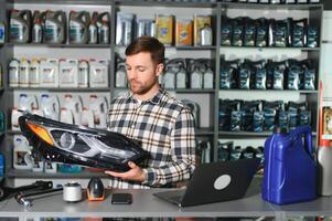 portrait de une Beau vendeur dans un auto les pièces magasin. le concept de voiture réparation photo