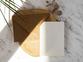 fond de marbre avec plaque en bois avec enveloppe marron blanc vierge photo