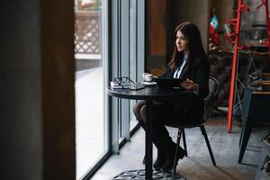 content Jeune femme d'affaires en utilisant tablette ordinateur dans une café. sélectif concentrer photo