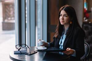 Jeune femme d'affaires en utilisant tablette ordinateur dans café magasin. photo