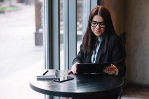 Jeune femme d'affaires en utilisant tablette ordinateur. femme sur une café Pause photo