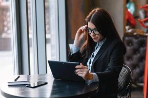 Jeune femme d'affaires en utilisant tablette ordinateur dans café magasin. photo