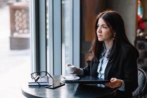 content Jeune femme d'affaires en utilisant tablette ordinateur dans une café. sélectif concentrer photo