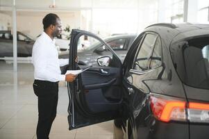 Jeune africain américain voiture concession principal permanent dans véhicule salle d'exposition photo